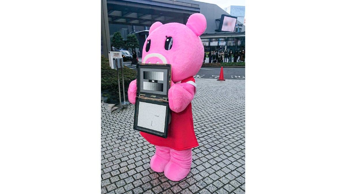 『Nスタ』中継スタッフのお手伝いで、「ホワイトバランス」ボードを持つBoonaさん