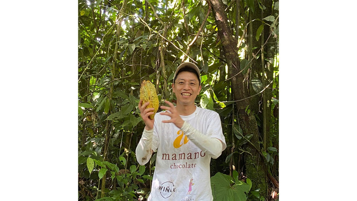 エクアドルのアマゾンでカカオの実を手にする江沢孝太朗さん