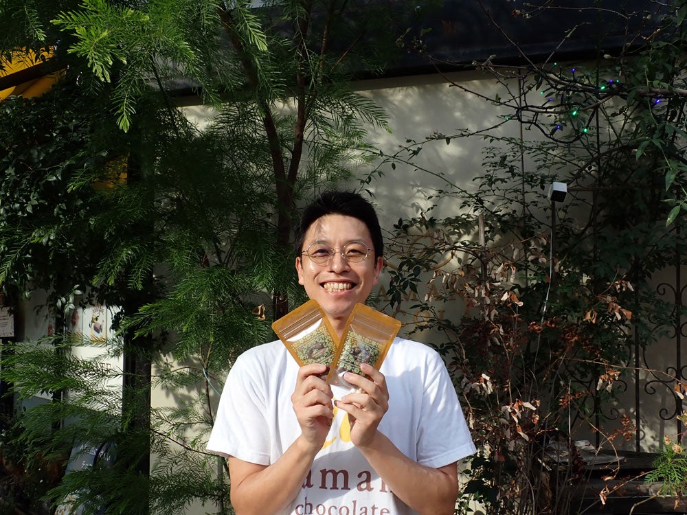 店頭に並ぶ商品の一部を手にする江沢孝太朗さん